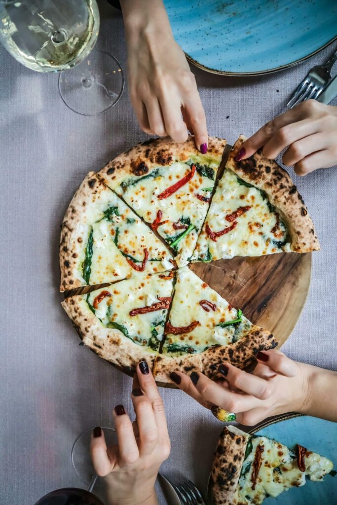 4 personer delar på en grönsakspizza.