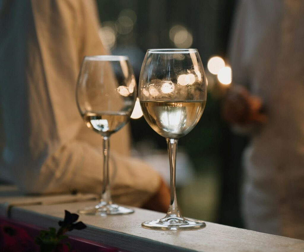 Två glas med Riesling med två personer som pratar i bakgrunden.